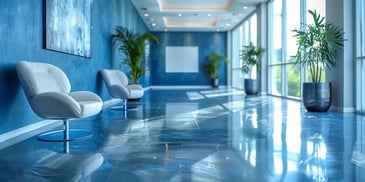 Sleek blue lobby with modern white chairs.