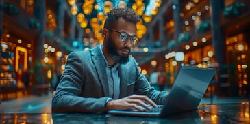 Man working on laptop in elegant, well-lit space.