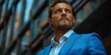 A confident man in a blue suit and white shirt looks upward with determination, set against a backdrop of modern buildings.