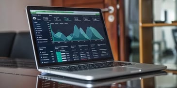 Laptop displaying financial graphs on desk.