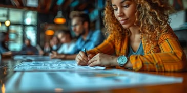 Focused woman writing at desk in meeting.