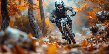 Mountain biker riding through autumn forest trail.