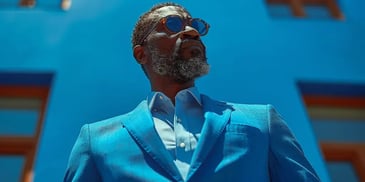 Man in blue suit with sunglasses.