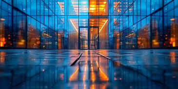 Modern glass building illuminated at night.