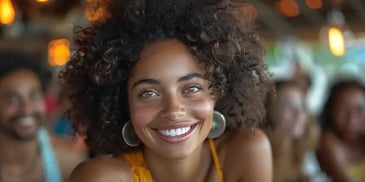 Smiling woman with curly hair wearing hoop earrings.