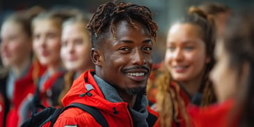 Smiling man in red jacket with group.