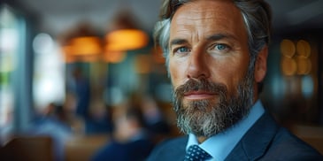Man with beard and blue eyes in suit.