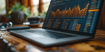 Laptop displaying financial graphs and data.