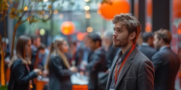 Man with red lanyard at a networking event.