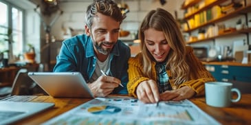 Couple happily reviewing charts at home.